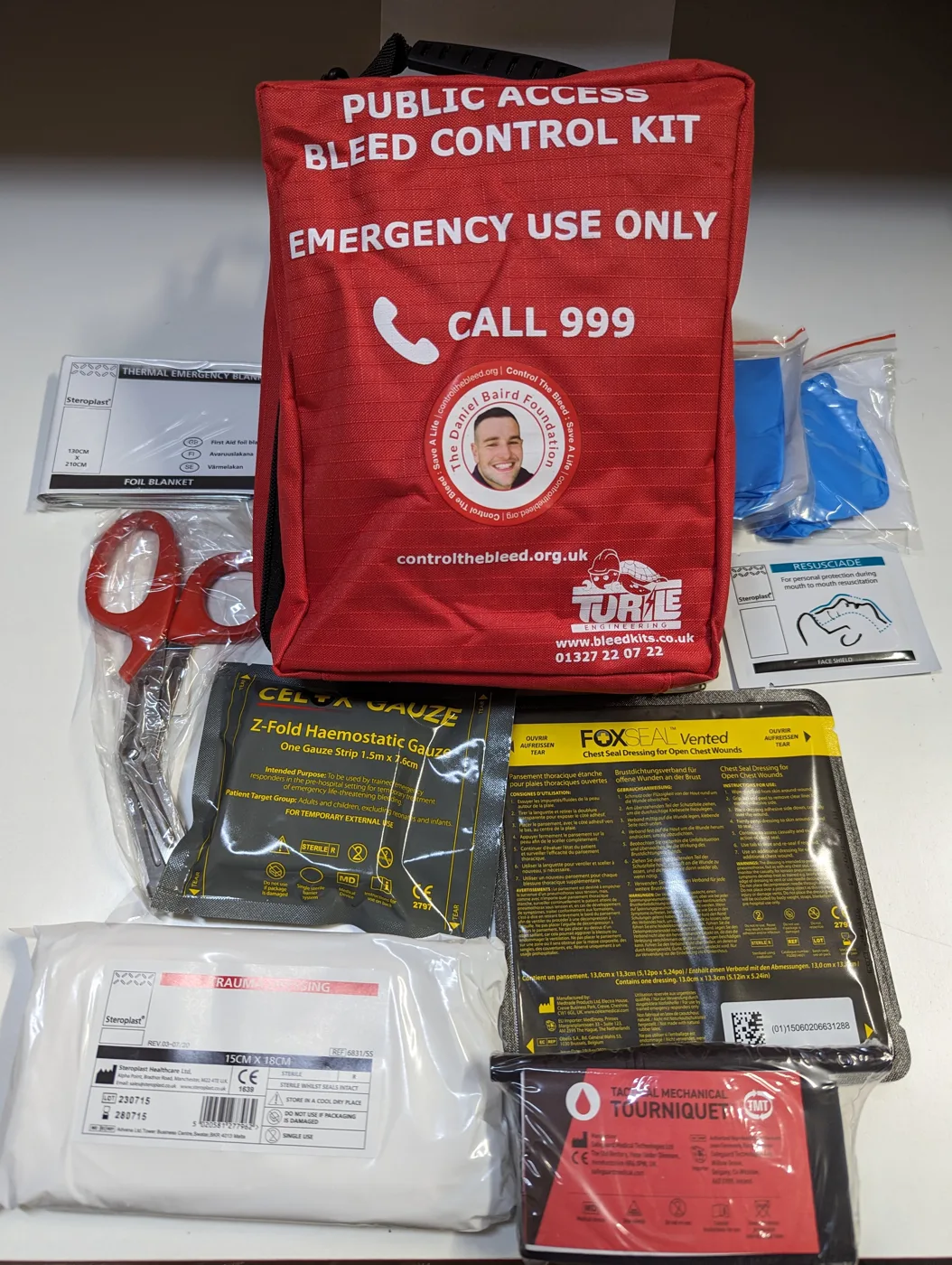 A public access bleed control kit with its contents laid out. This is an example of the type of kit, carrying another organisation's branding, and is not one of the six Oxford kits