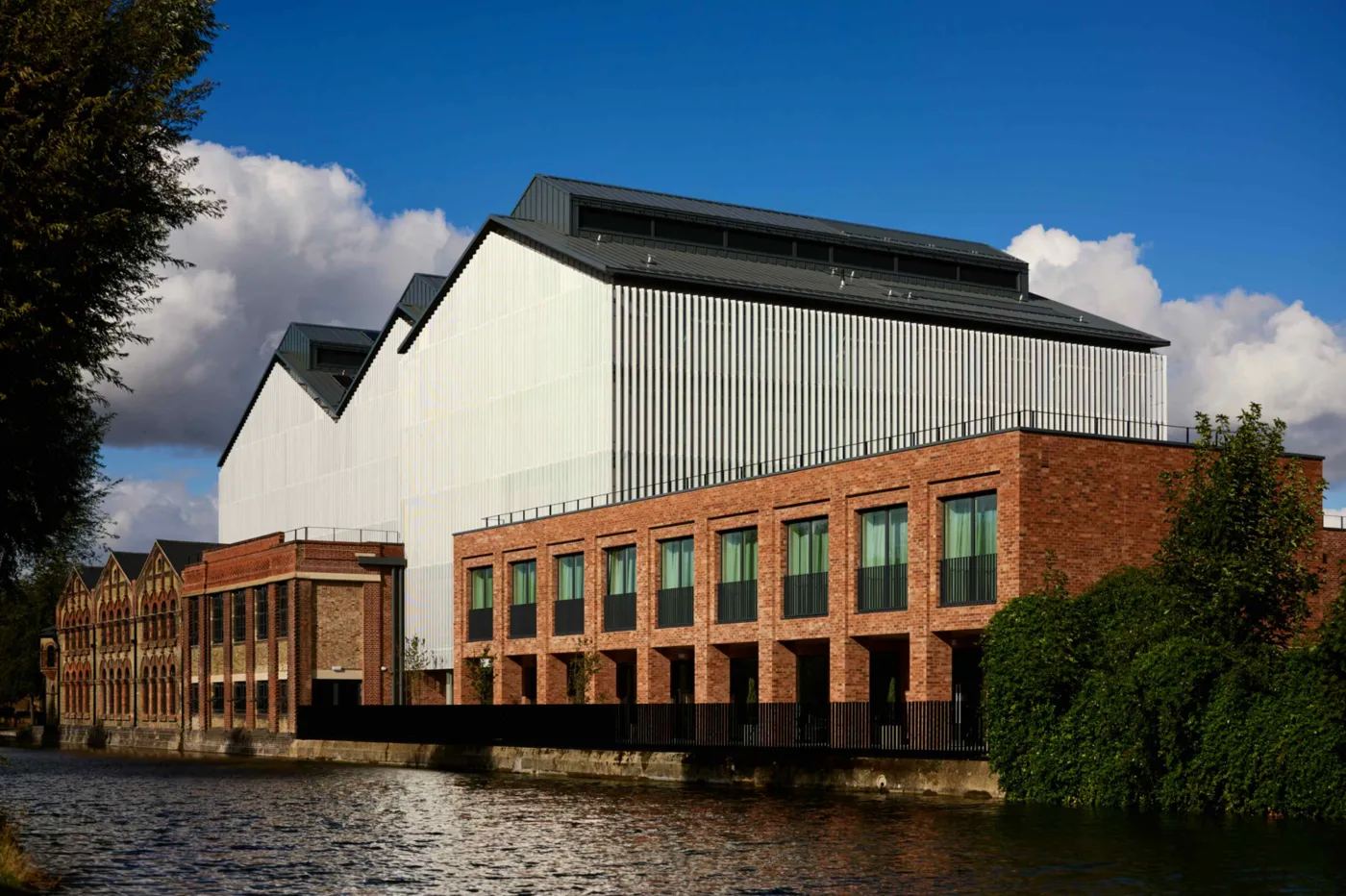 The Global Leadership Centre on the Thames at Osney, with the old power station's brick front below the new upper storeys